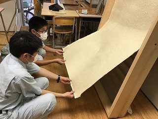 紙はがし：乾燥した竹紙を型枠から外す作業